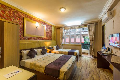 Habitación de hotel con 2 camas y TV en Hotel Acme Inn en Katmandú