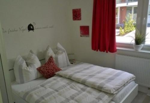 a bed in a room with a red window at Ostseebrise 4 - Großenbrode in Großenbrode