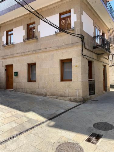 ceglany budynek z oknami i balkonem w obiekcie A de Maria - Tres Marias Apartments w mieście Redondela