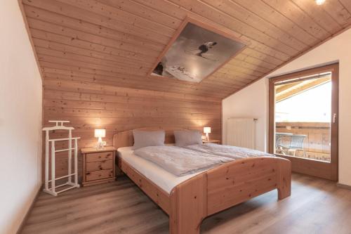 Schlafzimmer mit einem Bett mit Holzdecke in der Unterkunft Flo's Apartment in Großarl