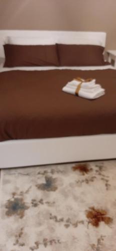 a bed with a brown comforter on top of it at Dimora Italia in Campobasso
