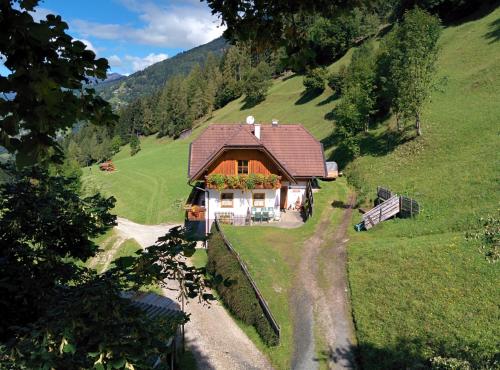 una piccola casa su una collina in un campo di Lercherhof a Feld am See