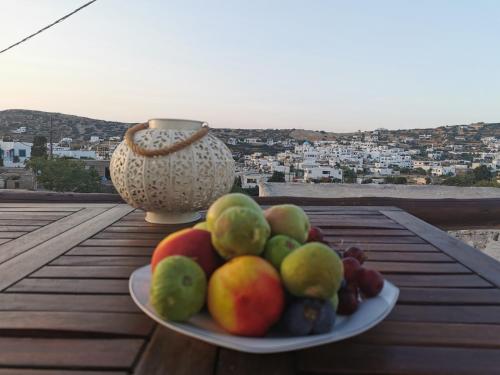 a plate of fruit on a table with a vase at Moscha's View House in Lipsoi