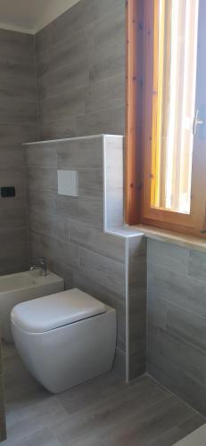 a bathroom with a toilet and a sink and a window at Soggiorno in Relax in Correggioverde