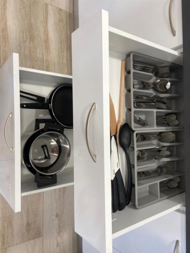a cupboard filled with dishes and utensils at Apartamentos Montalvo Alessandri in Torremolinos