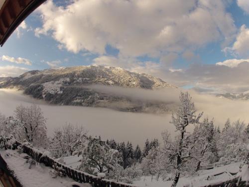 a view of a snow covered mountain with a lake at Lercherhof in Feld am See
