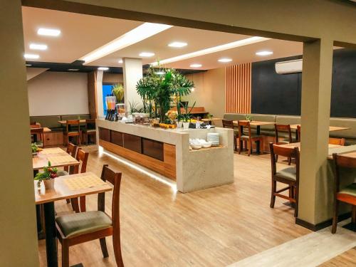 a restaurant with wooden tables and chairs and a counter at Presto Hotel in Blumenau