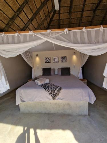 a bedroom with a large bed with a canopy at Pata Pata House in Marloth Park