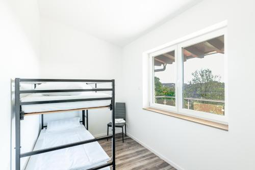 Zimmer mit Etagenbetten und Fenster in der Unterkunft Haus Jagstblick in Kirchberg an der Jagst