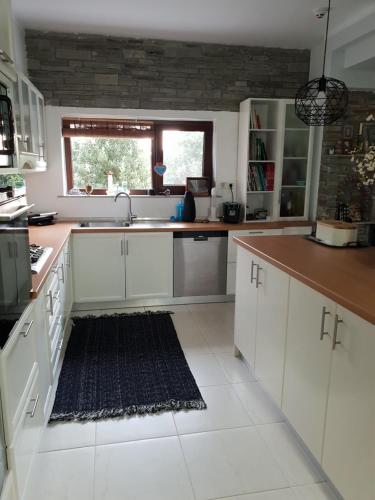 a kitchen with white cabinets and a sink at Mavridis House in Eleftheroúpolis