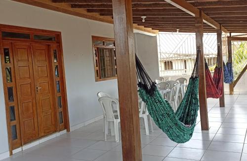 a couple of hammocks in a room with chairs at RESIDÊNCIA MORADA DO SOL in Nova Viçosa