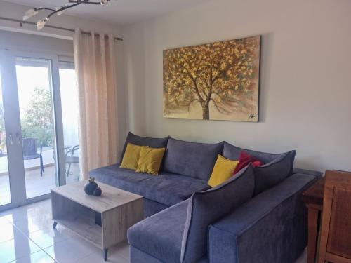 una sala de estar con un sofá azul y una pintura en la pared en Villa Vanessa, en Kissamos