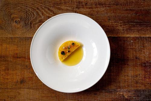 a piece of food on a white plate on a table at Là Di Moret in Udine