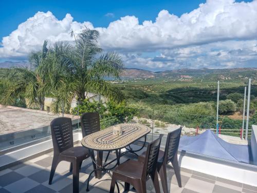 einen Tisch und Stühle auf einem Balkon mit Aussicht in der Unterkunft Villa Vanessa in Kissamos