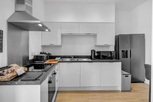 a kitchen with white cabinets and stainless steel appliances at Norwich Castle View Apt - Modern 2 Br in Norwich