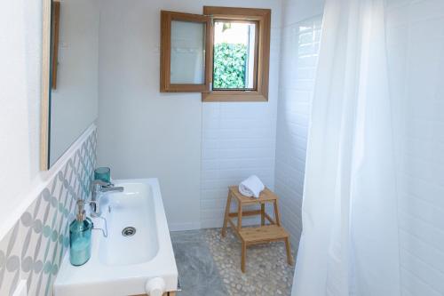 bagno con lavandino bianco e specchio di Villa with pool near the beach in Cala San Vicente by Renthousing a Cala Sant Vicenç