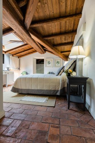 a bedroom with a bed and a table with a lamp at CORTE SAGGIN Charme Relais in San Pietro in Cariano
