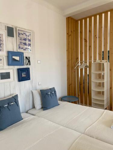 a bedroom with a bed with blue pillows and a shelf at Casa dos Carvalhos in Coimbra