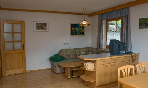 a living room with a couch and a television at Lercherhof in Feld am See