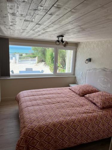 - une chambre avec un lit et une grande fenêtre dans l'établissement Le gîte des Falaises - plage à pied - vue sur mer, à Saint-Martin-Plage