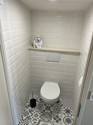 Elle comprend une petite salle de bains pourvue de toilettes blanches et de carrelage. dans l'établissement Le gîte des Falaises - plage à pied - vue sur mer, à Saint-Martin-Plage