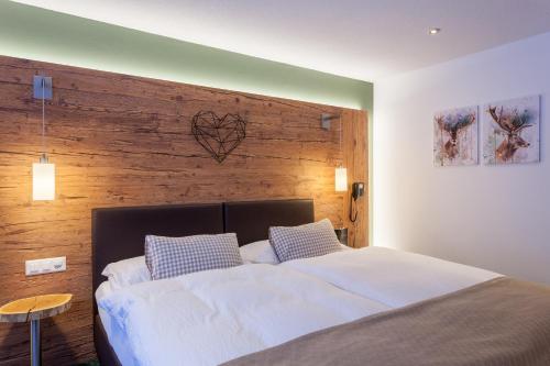 a bedroom with a large bed with a wooden wall at Hotel Jägerhof in Zermatt