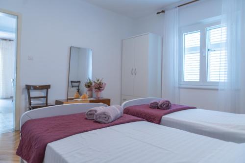 ein Schlafzimmer mit 2 Betten und Handtüchern darauf in der Unterkunft Sidus Maris in Martinšćica