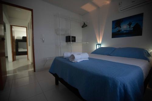 a bedroom with a blue bed with towels on it at Apartamentos Chalet del Mar in San Andrés