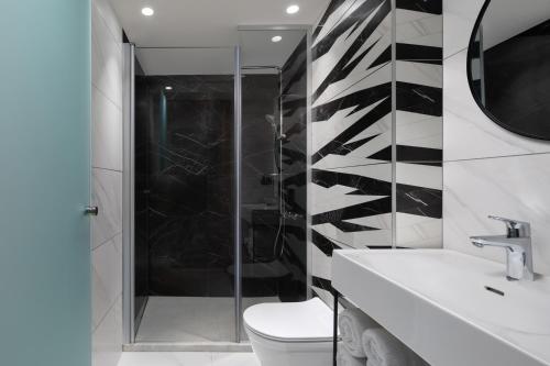 een badkamer met een douche, een toilet en een wastafel bij The Blend in Nazareth