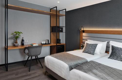 1 dormitorio con 2 camas y escritorio con silla en The Blend, en Nazaret