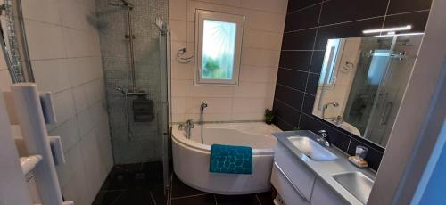 a bathroom with a tub and a sink and a shower at BASSIN D'ARCACHON, Maison vacances climatisée au calme, proche plage in Lanton