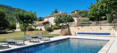 a swimming pool with lounge chairs next to a house at Mas De La Lance in Roche-Saint-Secret