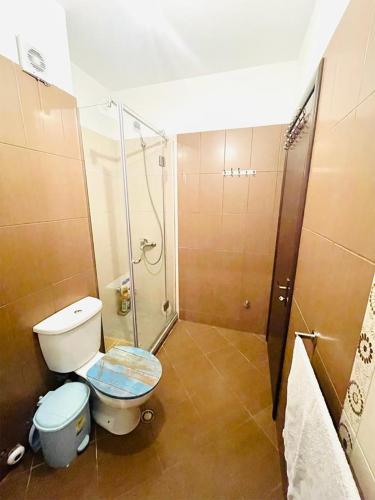 a bathroom with a toilet and a shower in it at Spacious Holiday Apartment in Tirana