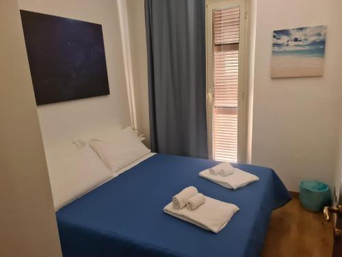 a bedroom with a blue bed with towels on it at Sunshine Apartment in Rome