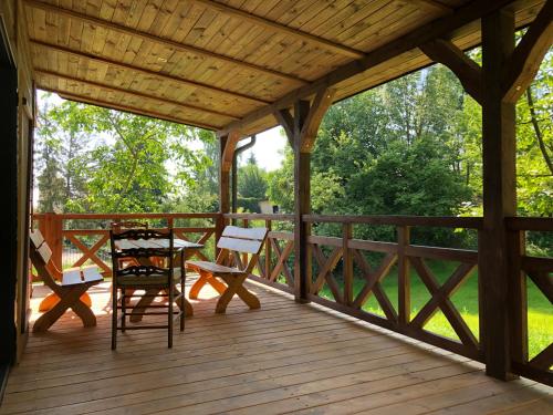 a wooden porch with a table and chairs on it at Na Tałandy in Szczebrzeszyn