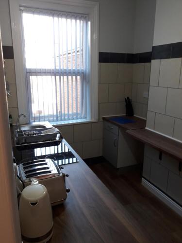 a kitchen with a stove and a sink and a window at Southbay Holiday Flats Flat 2 in Bridlington