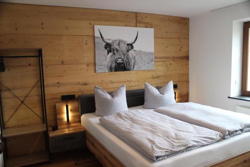 1 dormitorio con 1 cama con un toro en la pared en Ferienapartment Horn, en Altendorf