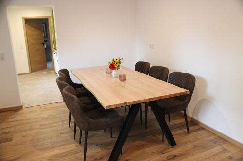 a dining room table with chairs and a wooden table at Ferienapartment Horn in Altendorf