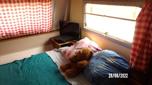 um urso de peluche deitado numa cama num quarto em Calme de la campagne em Le Torp-Mesnil