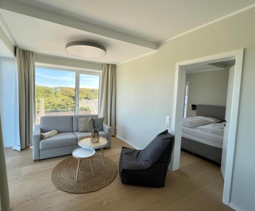 a living room with a bed and a couch and a table at Westeroog in Wangerooge