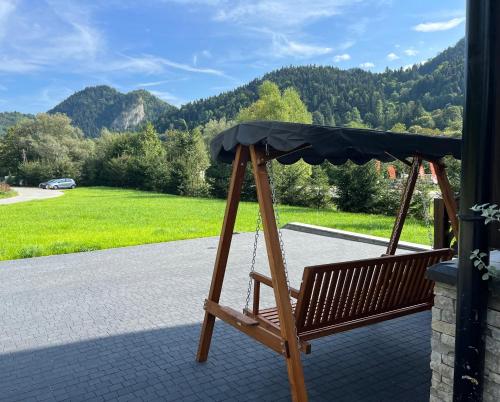 a swing on a porch with a view of the mountains at Willa FOLK Pieniny in Szczawnica