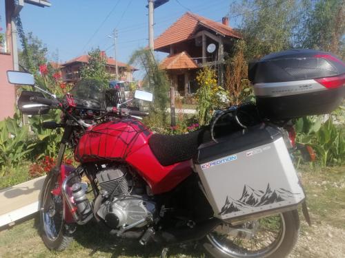 a red motorcycle parked in front of a house at Stancic 019 in Zaječar