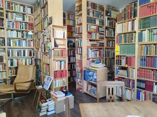 a library filled with books with a chair and a table at Schmökermühle in Andernach