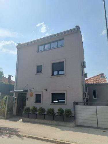 a white building with windows on the side of it at Nana / Sobe & Apartmani in Valjevo