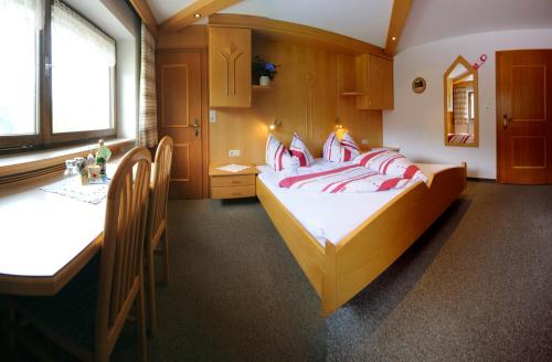 a bedroom with a bed with red and white pillows at Gästehaus Bergland in Berwang