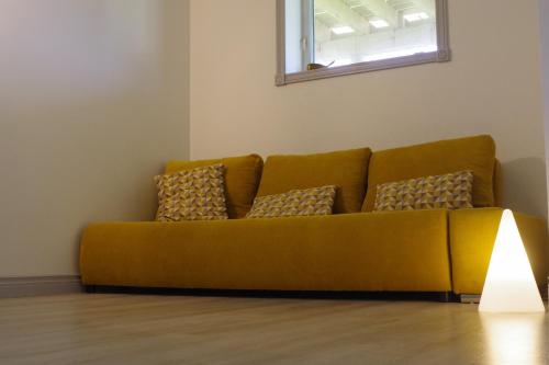 a yellow couch in a living room with a lamp at appartement bord de mer in Saint-Pierre