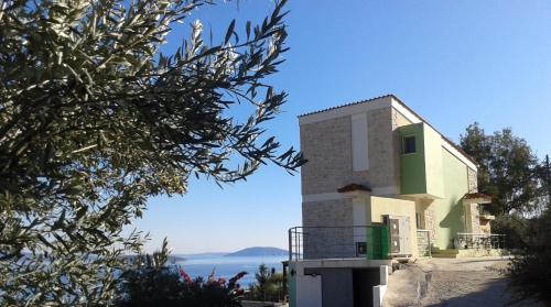 a house with a view of the ocean at Πέτρα, Ελιά και Λεβάντα in Tolo