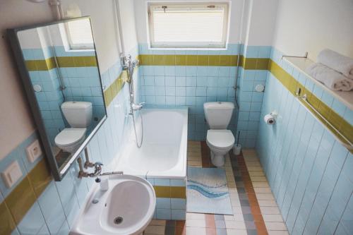 a bathroom with two toilets and a tub and a sink at Chalupa U lesa in Vápenice