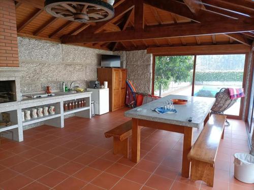 a kitchen with a table and a counter top at CASA DO LAGAR in Agilde