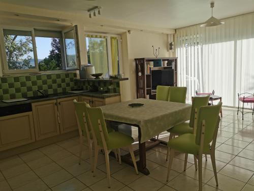 une cuisine et une salle à manger avec une table et des chaises dans l'établissement Appartement dans maison individuelle LE CAYLUS BAS, à Saint-Affrique